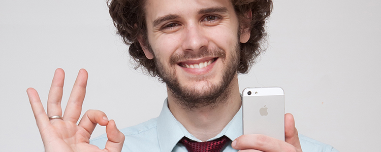スマホを持ってOKサインをする男性